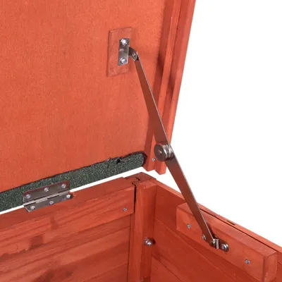 Närbild på gångjärn och metallstag som håller upp ett öppet lock av trä, visar konstruktionen inuti en trälåda eller hundkoja. Närbild på gångjärn och metallstag som håller upp ett öppet lock av trä, visar konstruktionen inuti en trälåda eller hundkoja.