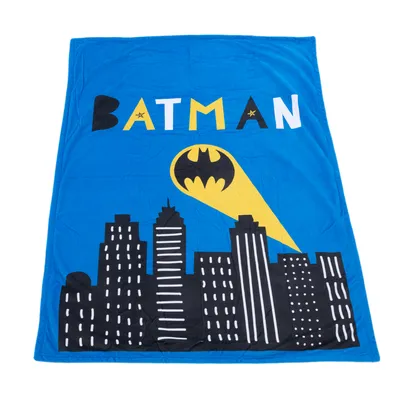 Blue blanket with Batman logo, yellow spotlight and skyline design.