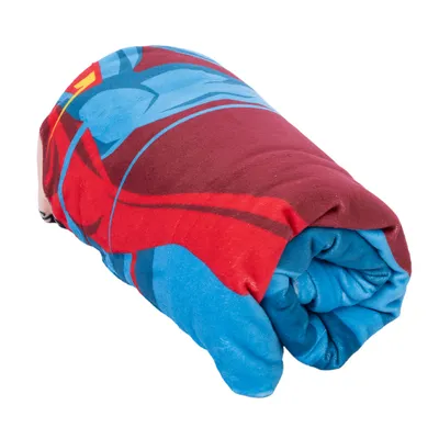 Couverture en tissu roulée, motifs colorés bleu, rouge et jaune visibles. Aucun texte ou marque apparente.