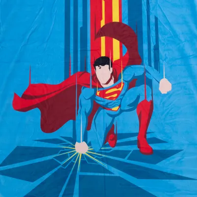 Couverture en tissu avec illustration de Superman en costume bleu et rouge, cape déployée, logo S jaune sur la poitrine, fond bleu à motifs graphiques.