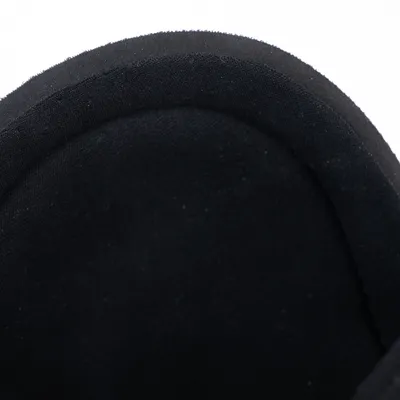 Nahaufnahme eines schwarzen Stoffmaterials mit gepolstertem Rand, möglicherweise Teil eines Tierprodukts.