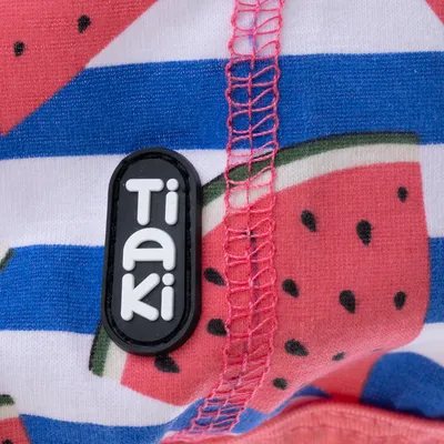 Tiaki-Logo auf Stoff mit Wassermelonenmuster und blauen Streifen.