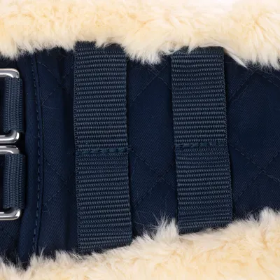 Close-up van donkerblauwe, gewatteerde stof met twee stevige banden en zachte crèmekleurige imitatiebontafwerking.