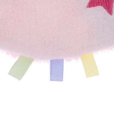 Detailaufnahme eines rosa Stoffspielzeugs mit bunten Schlaufen in Pastellfarben und einem roten Sternmotiv.