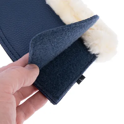 Gros plan sur une main tenant un accessoire en tissu bleu avec intérieur doux et bordure imitation fourrure blanche, étiquette noire marquée 'L' visible.