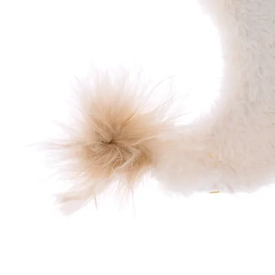 Close-up of a beige plush toy with a fluffy pompom at the end.