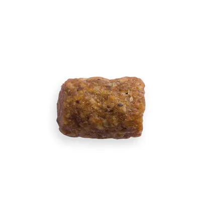 Närbild av ett brunt, rektangulärt hundsnacks med synliga korn och strukturerad yta.