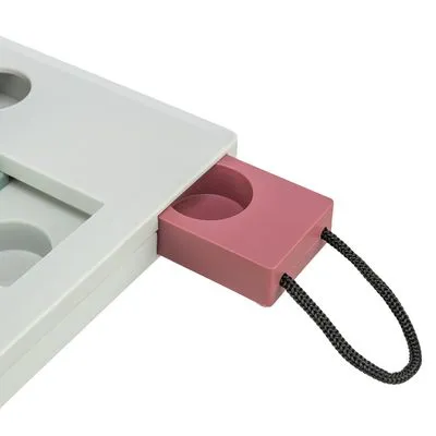 Detail van een interactief huisdierenspeelbord met uitschuifbaar roze bakje en zwart koord, gemaakt van kunststof. Meerdere ronde vakjes zichtbaar.