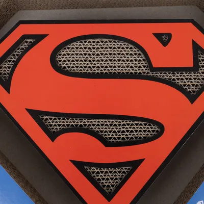 Krabplank van karton met Superman-logo in rood en zwart.