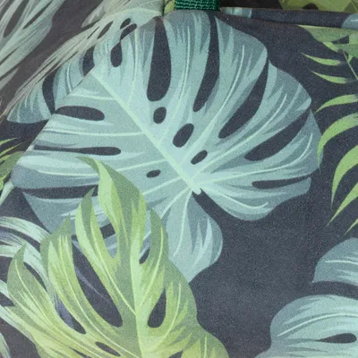 Primer plano de un diseño de hojas tropicales en tonos verdes y azules sobre tela.