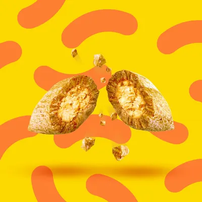 Dva prelomljena kosa suhe pasje hrane z vidnim polnilom, rumena podlaga z oranžnimi vzorci.