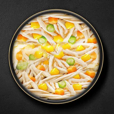 Крупный план миски с куриными полосками, кусочками жёлтой тыквы и зелёным горошком.
