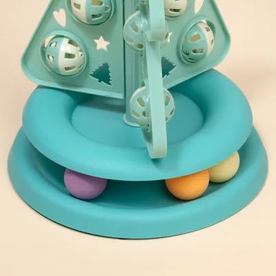 Jouet interactif pour chat en plastique turquoise, forme d’arbre avec balles colorées et motifs découpés (étoiles, sapins) visibles sur la structure.