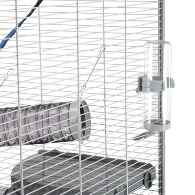 Cage à barreaux blancs avec biberon en plastique transparent fixé, tunnel suspendu en plastique gris et plateforme intérieure grise visibles.