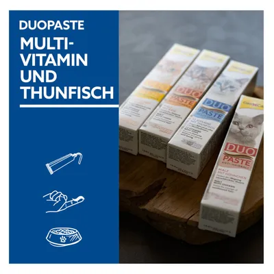 GimCat DuoPaste Multivitamin und Thunfisch. Anti-Haarballen, Malz mit Hühnchen. Produktabbildung von vier Pasten auf Holzunterlage.