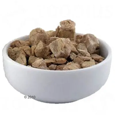 White bowl with brown, dried food pieces. Product image of dry food or snacks.