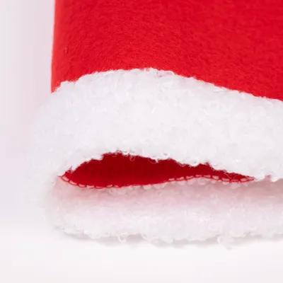Detailansicht eines roten Stoffes mit weißem, flauschigem Rand. Materialstruktur ist deutlich sichtbar. Detailansicht eines roten Stoffes mit weißem, flauschigem Rand. Materialstruktur ist deutlich sichtbar.