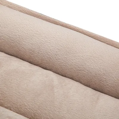 Detailopname van beige pluche stof met zachte, gewatteerde structuur, zichtbaar materiaal van een huisdierbed of kussen.