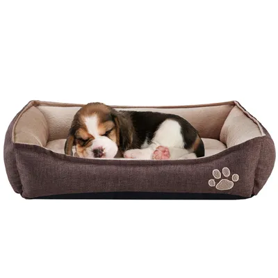 Bruin rechthoekig hondenbed met opstaande randen en beige binnenkant, voorzien van een pootafdrukmotief aan de voorkant. Hond ligt in het bed.
