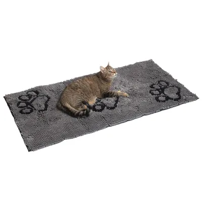 Grå matta med svarta tassavtryck, en tigrerad katt ligger på den.