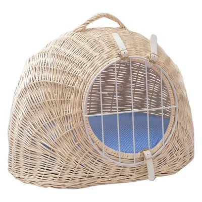 Round carrier basket made of light rattan with white metal grid and blue padded interior. Two white leather straps secure the grid.