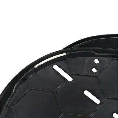 Close-up of a black plastic tray with multiple slots and holes, showing details of its structure and drainage design.