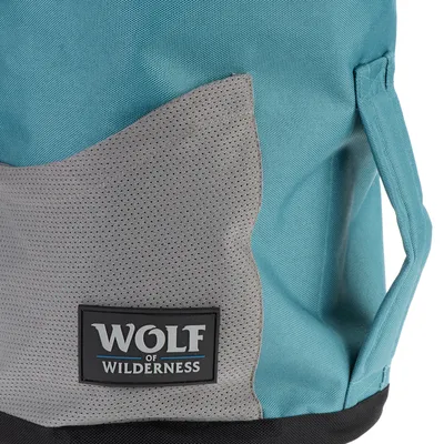 Wolf of Wilderness logó egy szürke és türkiz szövetből készült táskán, hordozófogantyúval.