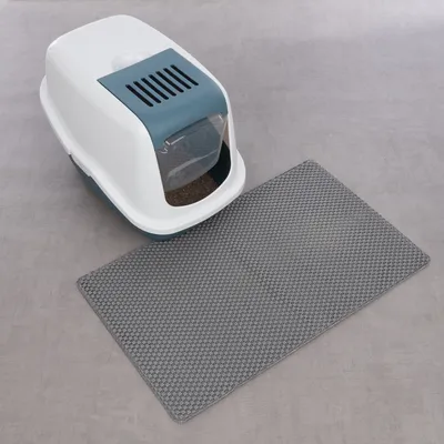 Caja de arena cerrada para gatos con alfombrilla gris, adecuada para minimizar la dispersión de arena.