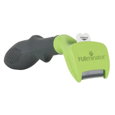 Cepillo para mascotas Furminator con mango negro y verde, púas metálicas visibles y botón FURjector en la parte superior.