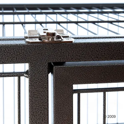 Метална врата с решетка и метална закопчалка, показваща детайл на заключващия механизъм. Видими са прави линии и текстура на повърхността.