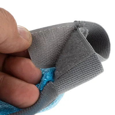 Nahaufnahme eines grauen Klettverschlusses an einem blauen Stoffband, gehalten von einer Hand.
