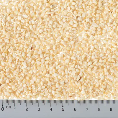 Nahaufnahme von zerkleinertem Material mit Massstab in Zentimetern, zeigt Partikelgrösse bis ca. 5 mm.
