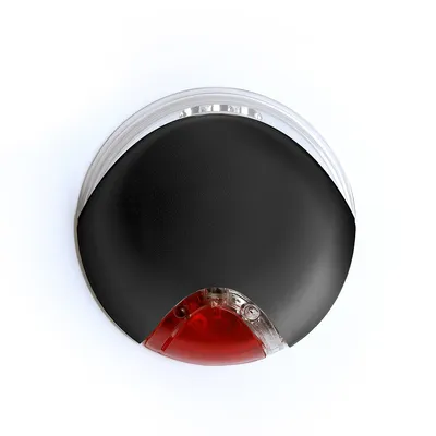 Objet rond en plastique noir avec une partie transparente et un segment rouge, vu de dessus. Aucun texte ou marque visible.