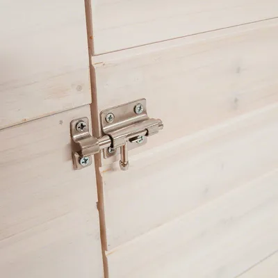 Detailweergave van een zilverkleurige metalen sluiting op een licht houten oppervlak, geschikt voor het beveiligen van deuren of kleppen.