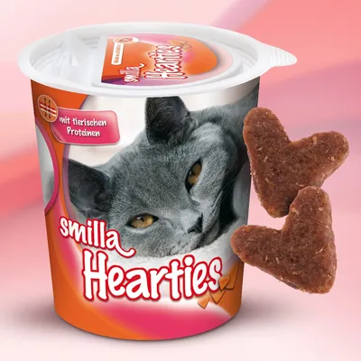 Smilla Hearties posuda s fotografijom sive mačke, natpisima 'mit tierischen Proteinen' i 'smilla Hearties', uz dva smeđa keksića u obliku srca ispred ambalaže.