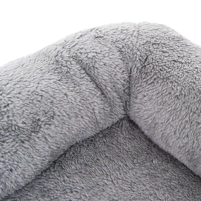 Närbild av grått, fluffigt tygmaterial, möjligen del av en husdjursbädd eller filt.