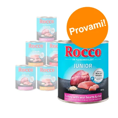 Scatolette Rocco Junior, visibile variante tacchino con cuori di vitello e riso, 800 g. Testo sull'etichetta: 'Supports healthy growth'. Bollino arancione con scritta 'Provami!'.