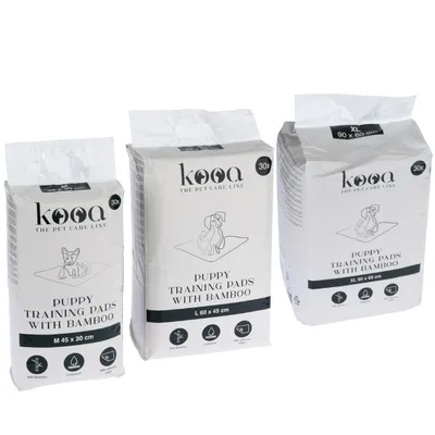 kooa Puppy Training Pads with bamboo, sizes M 45x30 cm, L 60x45 cm, XL 90x60 cm. Packaging shows symbols for bamboo material, waterproof and leakproof. Contains 30 pads per pack.