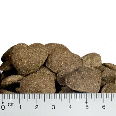 Snacks marrones en forma de corazón con indicación de tamaño mediante regla en centímetros, longitud aprox. 4 cm.