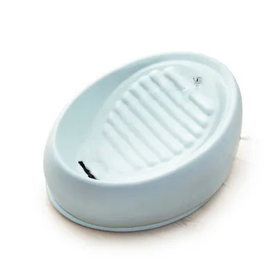 Fuente de agua para mascotas de color blanco con superficie ondulada y chorro de agua visible en la parte superior.