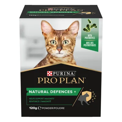 Purina Pro Plan Natural Defences+ powder for cats, 120g box. Visible text: with postbiotics, helps support immunity. Green and black packaging with cat photo on front.