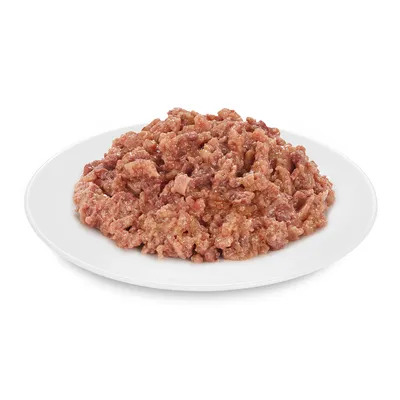 Közelkép tálalt nedves eledelről fehér tányéron, húsos darabok nedves állagban.