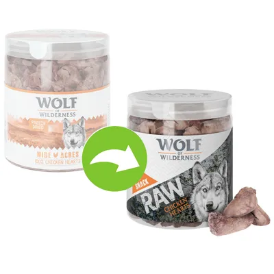 Dve dózy Wolf of Wilderness: Wide Acres 100% Chicken Hearts a RAW Chicken Hearts, sušené kuracie srdcia. Viditeľné kúsky produktu vedľa dózy. Zelená šípka medzi obalmi.