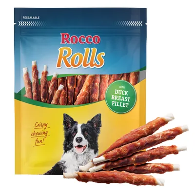 Rocco Rolls ankansisäfileellä. Pakkauksessa koira ja välipalatikkuja. Teksti: "Crispy chewing fun!" Uudelleensuljettava.