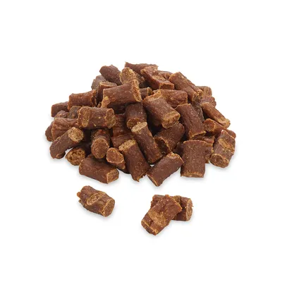 Ein Haufen brauner, zylindrischer Hundesnacks aus getrocknetem Fleisch. Keine Verpackung sichtbar.
