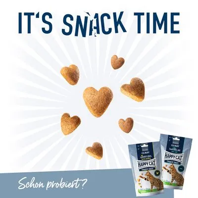 Twee zakjes Happy Cat Crunchy Snack met afbeelding van kat, hartvormige snacks. Tekst: IT'S SNACK TIME. Onderaan: Schon probiert? (Duitse tekst).