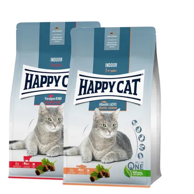 To poser Happy Cat kattefoder, Indoor 1+ years. Varianter: Voralpen Rind (Bavarian Beef) og Atlantik Lachs (Atlantic salmon). Billede af grå kat på begge poser.