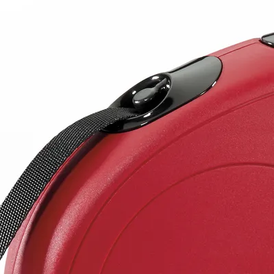 Dettaglio di guinzaglio avvolgibile rosso con pulsante nero e fettuccia nera visibili. Materiale plastica.