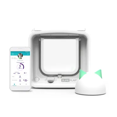 Puerta para mascotas SureFlap blanca, dispositivo con orejas verdes y móvil mostrando la app de actividad. Marca y nombre 'SureFlap' visibles en el producto.