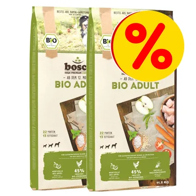 2 sacchi Bosch Bio Adult 11,5 kg con etichetta percentuale gialla. Testo visibile: 22 proteine, 13% grassi, 45% bio-mela, 45% bio-pollo, per cani adulti di tutte le razze.